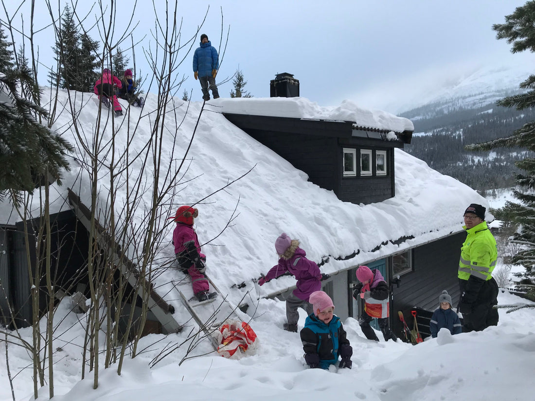 family speeds down the snowy rooftop as a fun winter activity